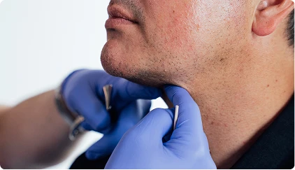 Medical professional examining patient's thyroid gland with gloved hands during clinical checkup - Chin implants in San Antonio, TX