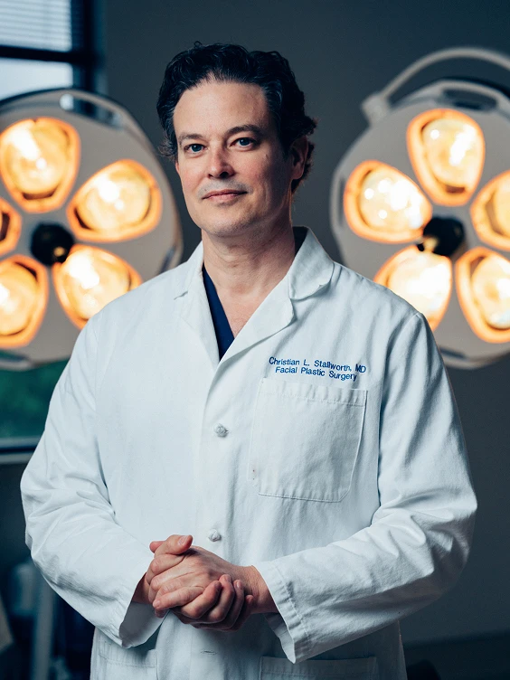 Doctor Stallworth MD in white coat standing confidently in front of surgical lights in operating room - doctor in San Antonio, TX