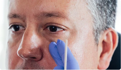 Man having blue glove against his face during examination, close up - Eyelid surgery in San Antonio, TX