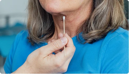 Woman in blue shirt holding cotton swab near mouth for at-home health test or DNA sample - Neck lift in San Antonio, TX