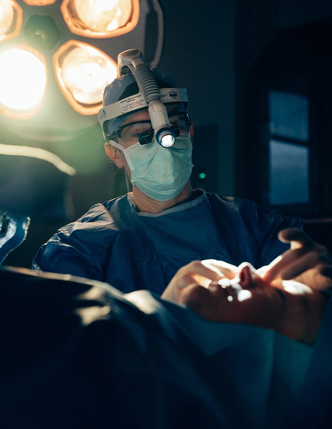 Dr Stallworth MD performing operation in operating room with surgical lights and medical equipment - Functional rhinoplasty in San Antonio, TX